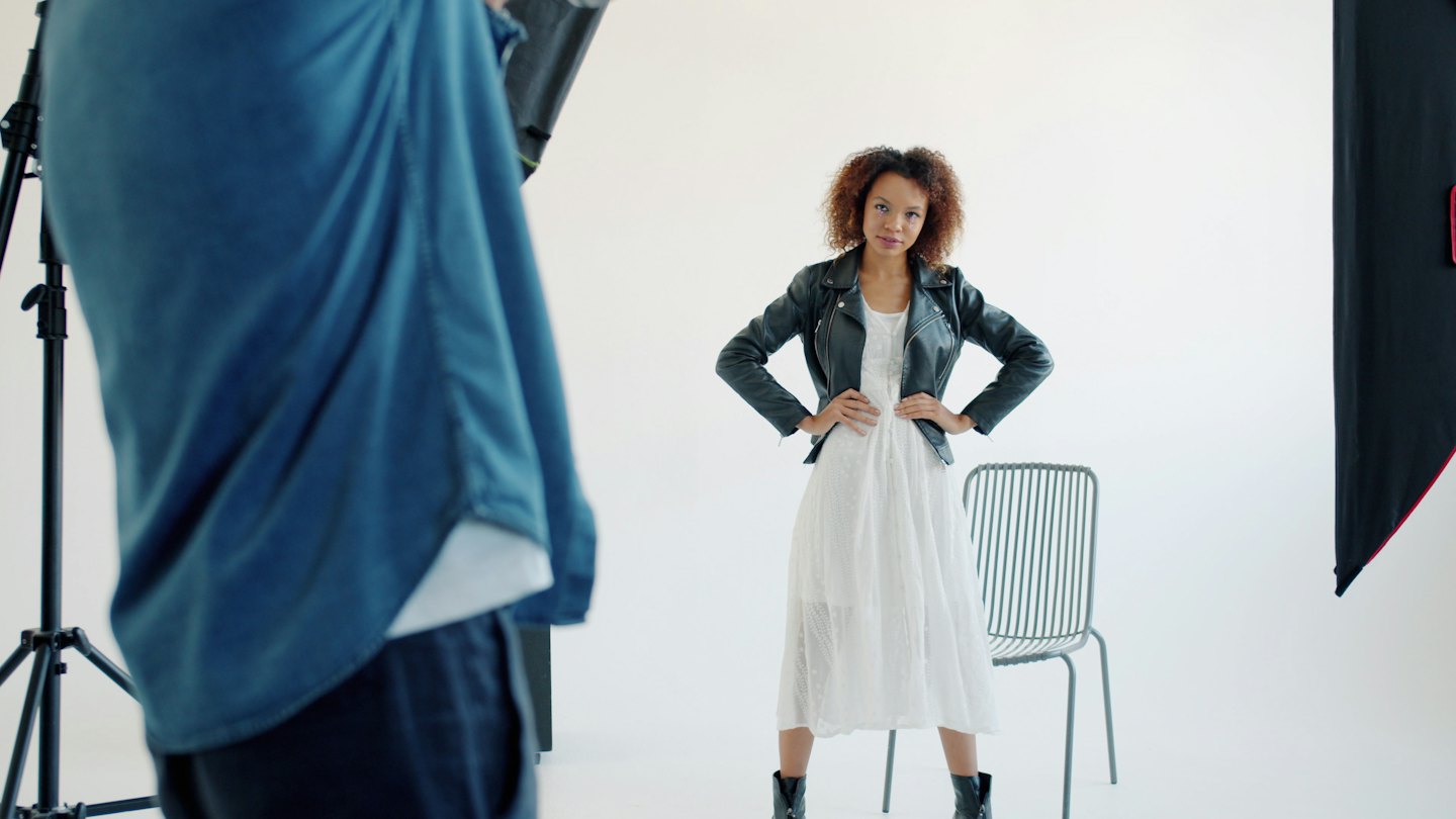 Fotografo che scatta una foto a una modella in studio.