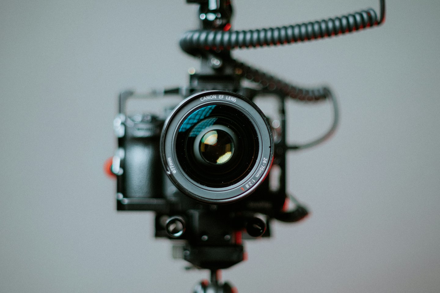 Obiettivo di una fotocamera professionale montato su un rig con cavi.