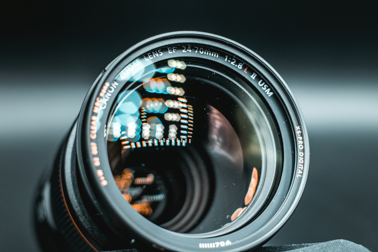Obiettivo di una fotocamera professionale appoggiato su una superficie minimalista da studio.