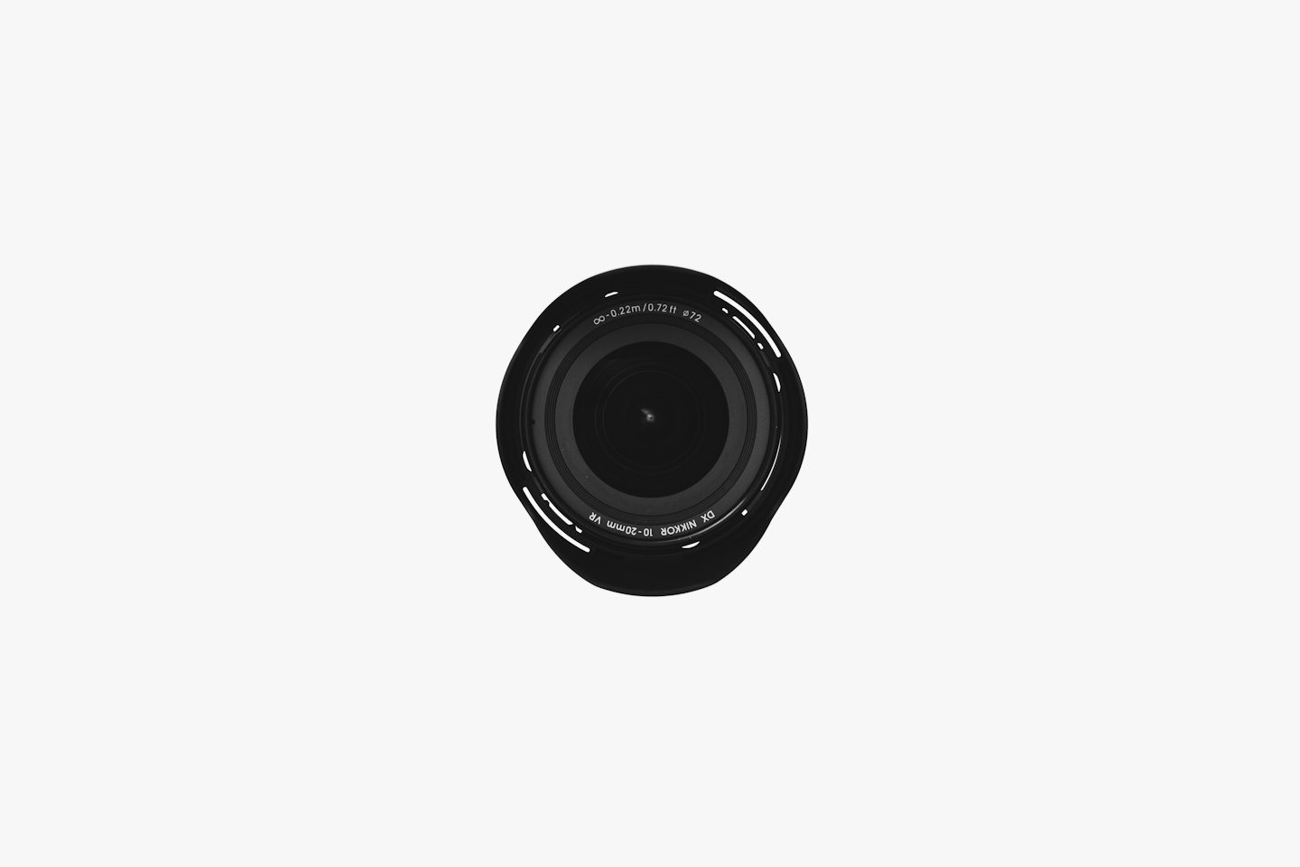 Obiettivo di fotocamera nero su superficie bianca.