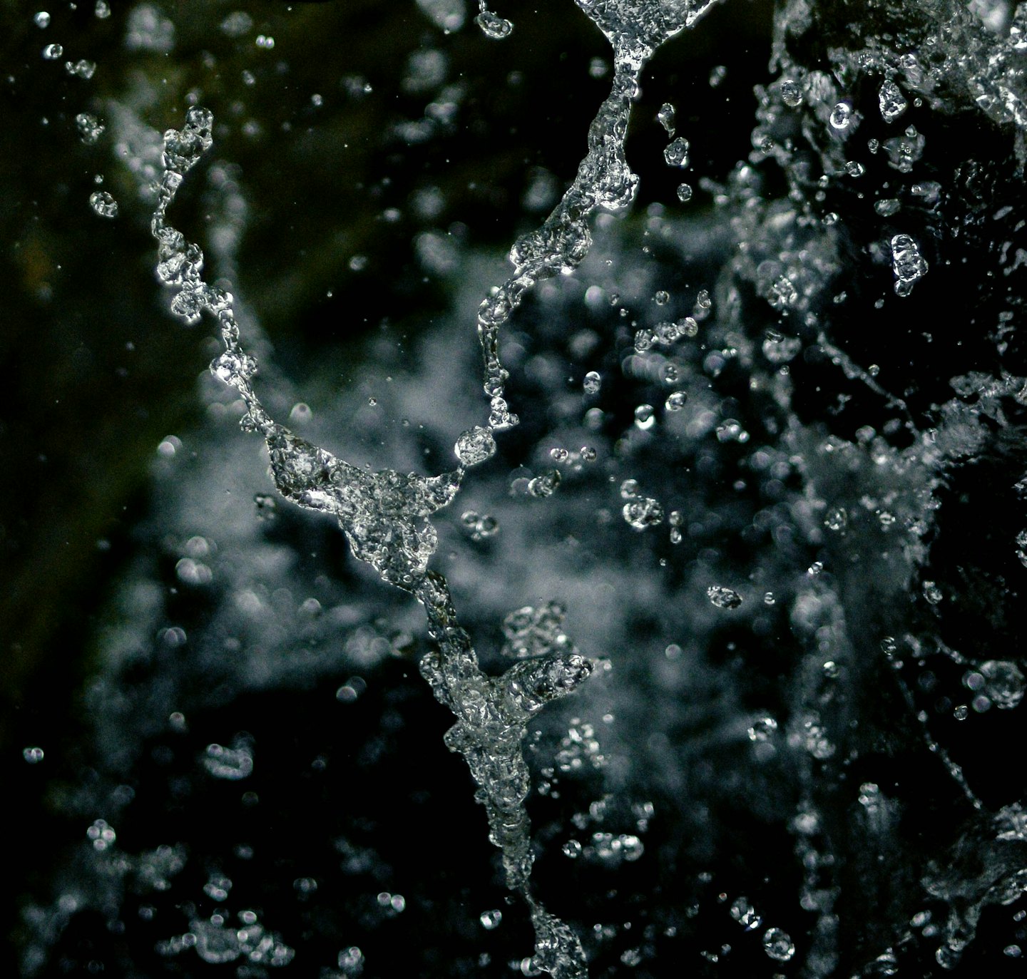 L'acqua limpida schizza in intricati rivoli e goccioline.